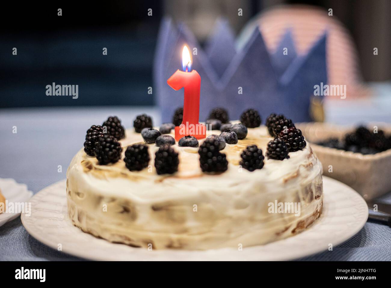 Simple homemade birthday cake for one year old baby party, with berries and red candle. Stock Photo