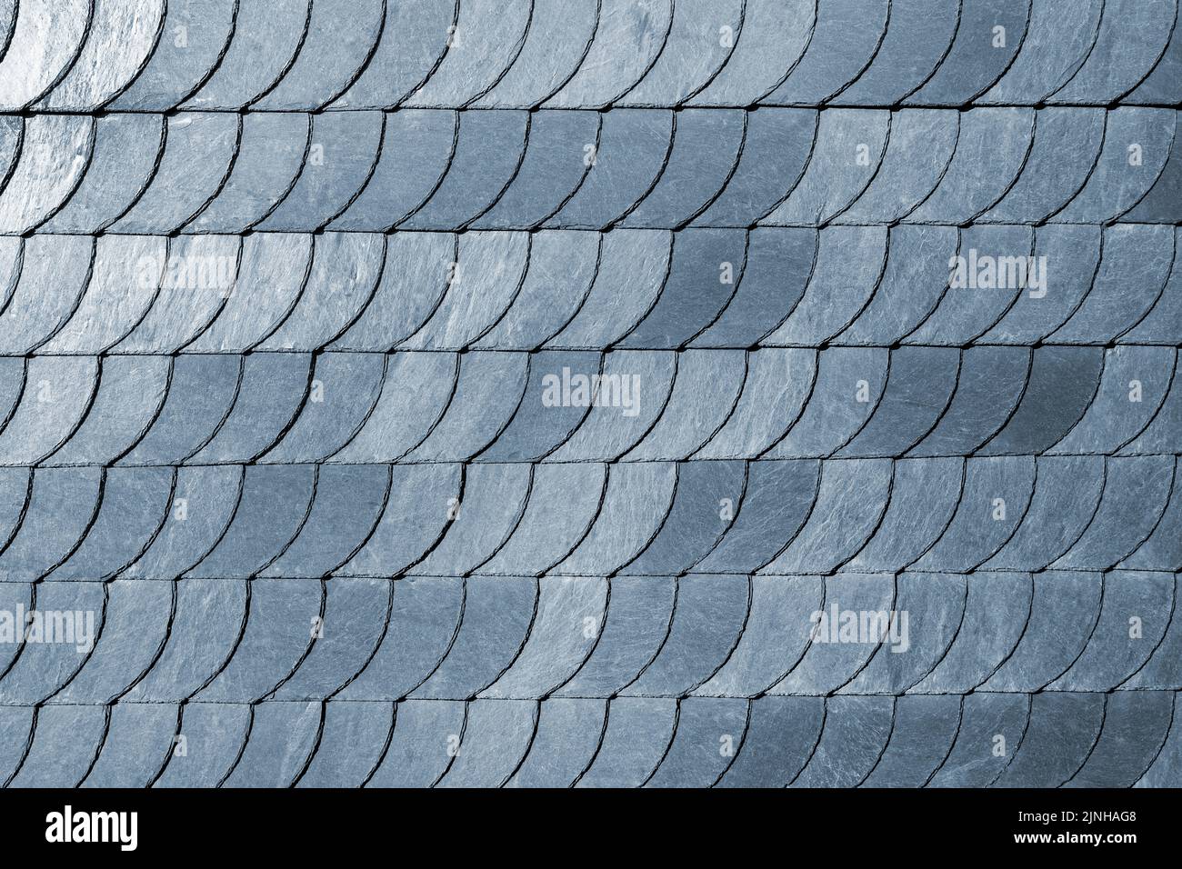 Detail closeup of natural grey stone shingle slate tiles texture roof abstract surface