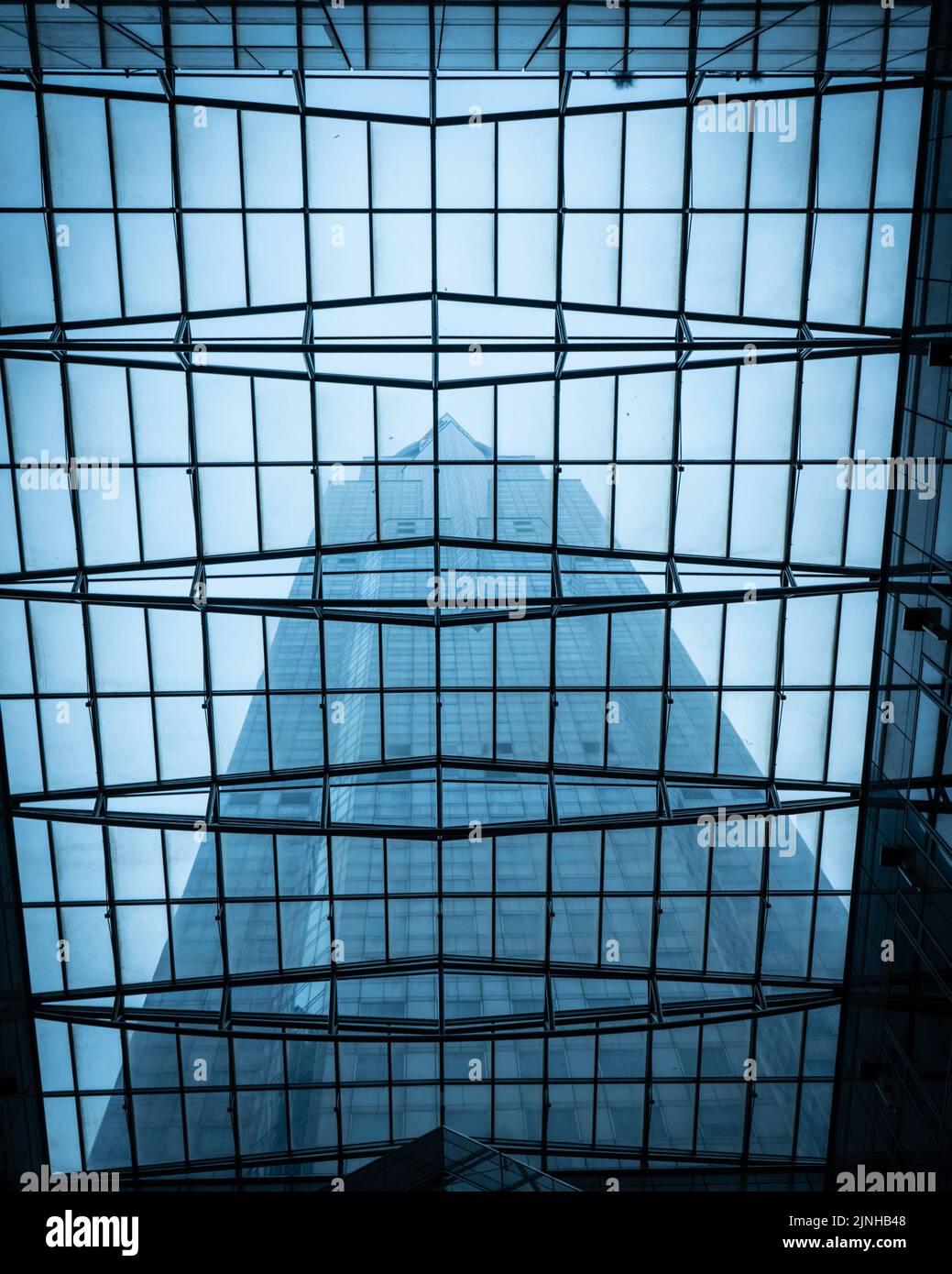 A vertical shot of a reflection of a modern building through a glass