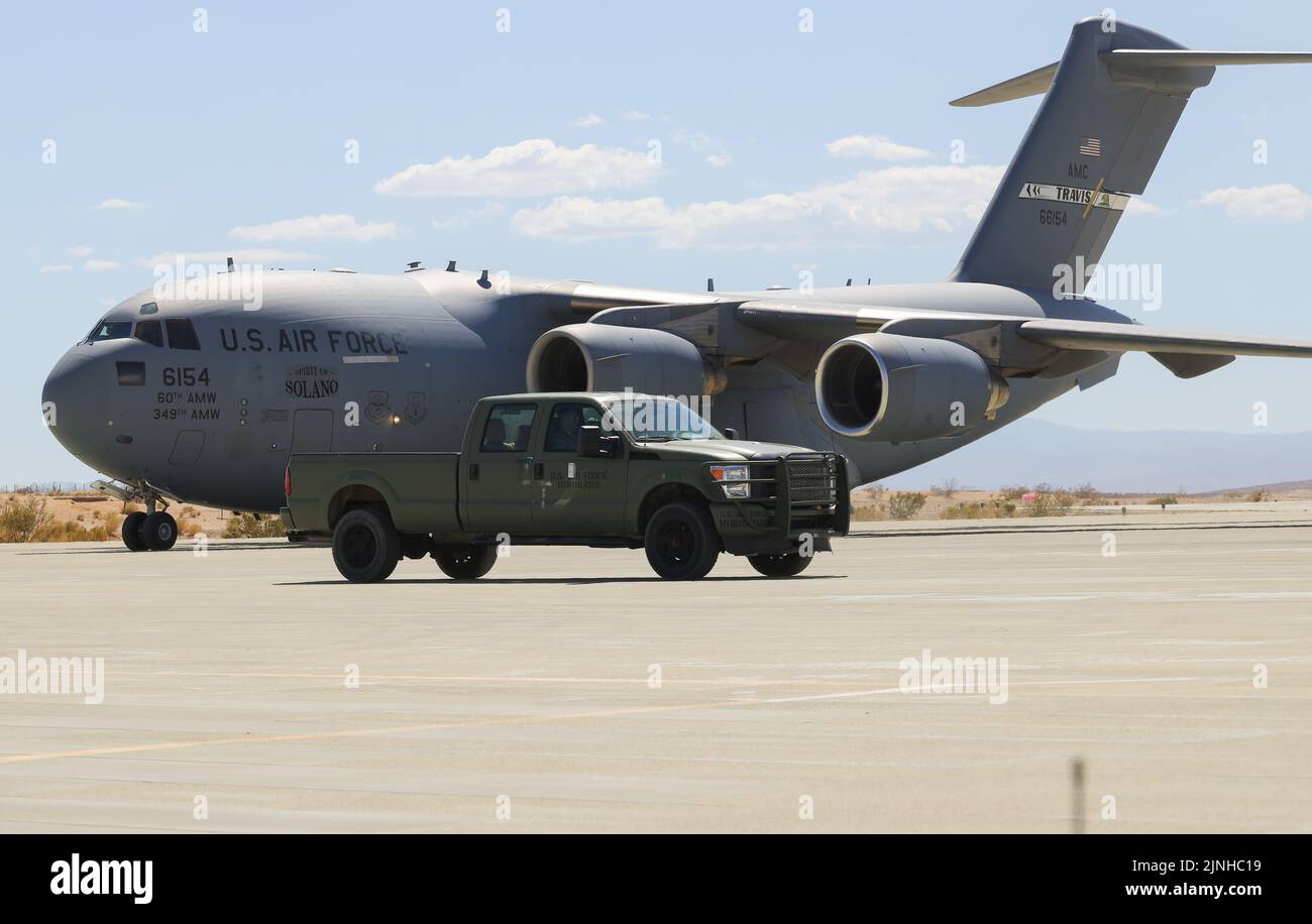 A U.S Air Force C-17 Globemaster III aircraft with the 21st Airlift Squadron, 60th Air Mobility Wing (AMW) lands at the Strategic Expeditionary Landing Field for joint exercise Patriot Hook at Marine Corps Air Ground Combat Center, Twentynine Palms, California, June 29, 2022. Air Force 60th AMW delivered Marine Corps UH-1Y Venom helicopters and AH-1Z Viper helicopters to conduct strike missions, testing Marine Light Attack Helicopter Squadron 267 (HMLA-267) rapid deployment capabilities. (U.S Marine Corps photo by Lance Cpl. Pedro Arroyo Jr.) Stock Photo