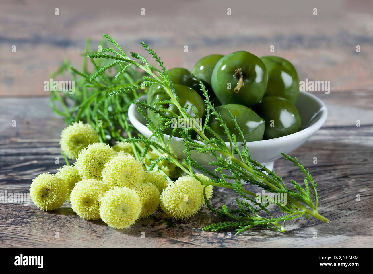 Bowl of green olives and green santolina Stock Photo
