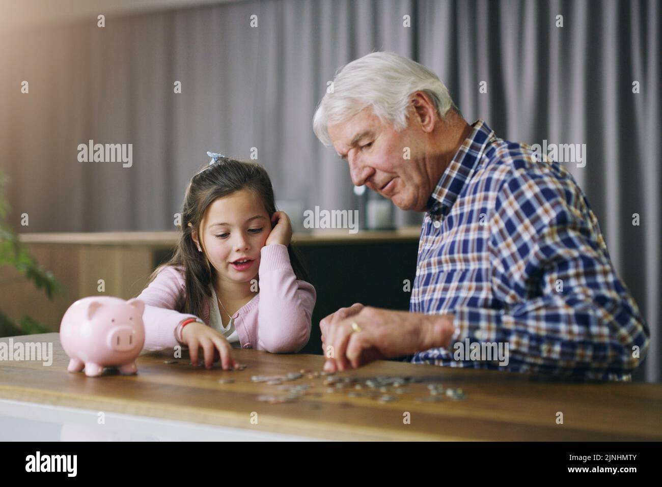 One day itll grow into a big money tree. a little girl learning about money from her grandfather. Stock Photo