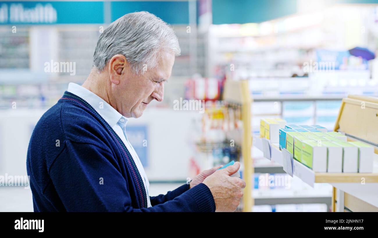 Its never too late to choose living a healthier life. Close up shot of a senior citizen deciding on which medicine to purchase at a pharmacy. Stock Photo