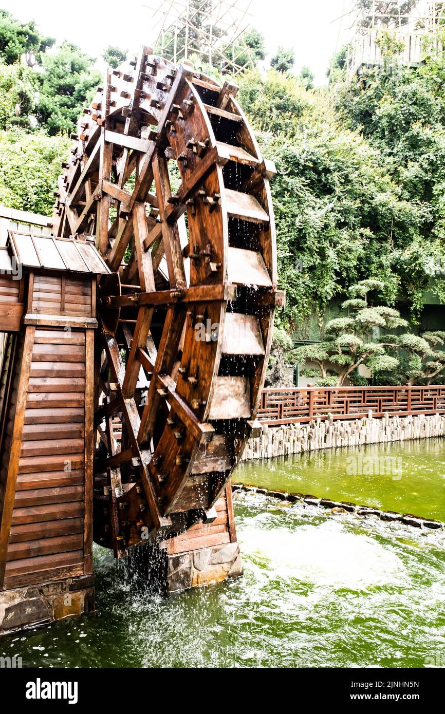 A vertical shot of an ancient water mill wheel at Nan Lian Gardens