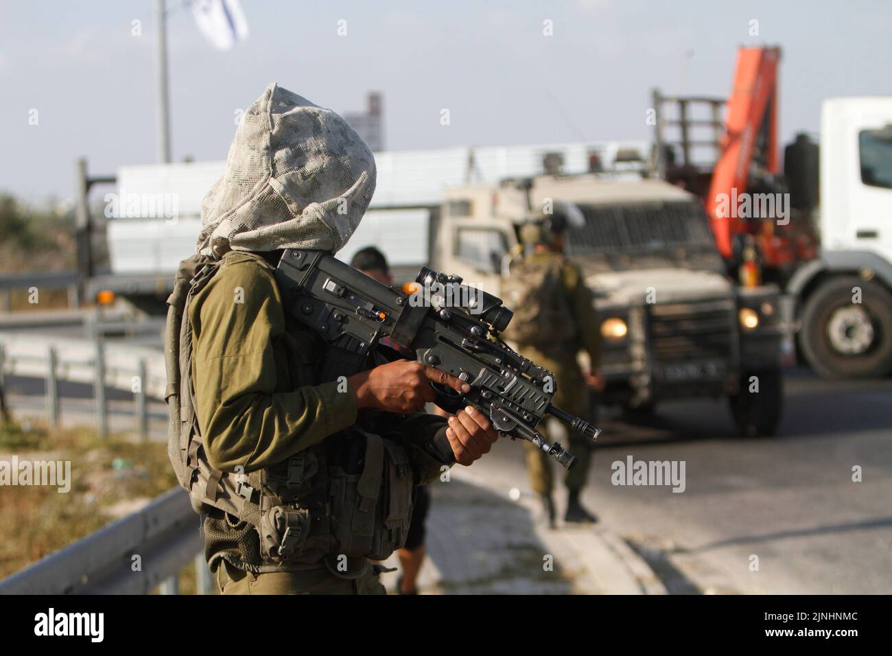 Qalqilya, West Bank, Palestine. 2nd Aug, 2022. An Israeli soldier seen carrying his weapon during a protest against Israeli settlement, expansion and land confiscation in the village of Ezbet El Tabib near Qalqilya in the occupied West Bank. (Credit Image: © Nasser Ishtayeh/SOPA Images via ZUMA Press Wire) Stock Photo