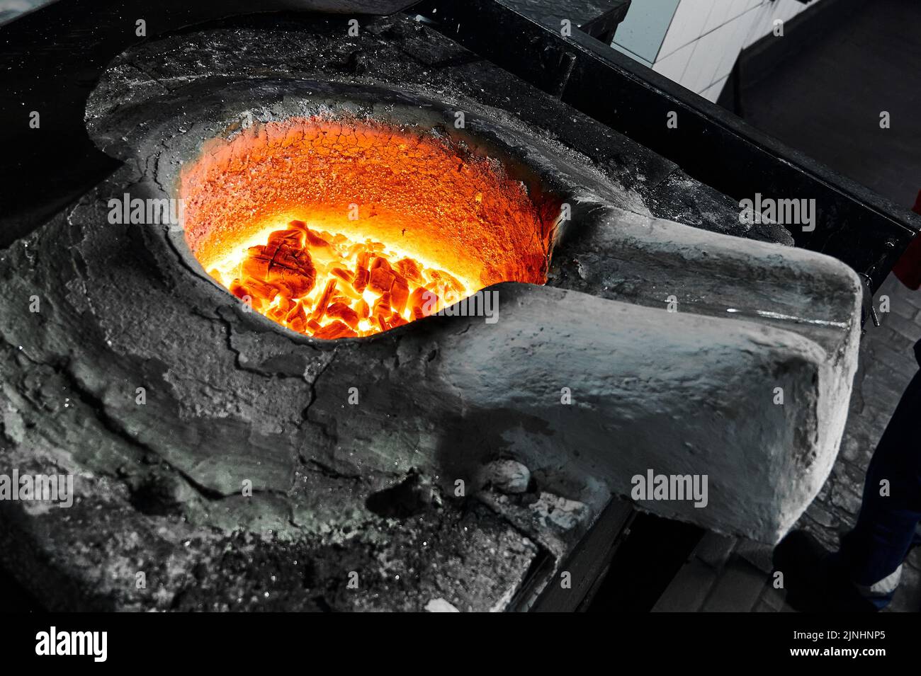 Metal with flux layer in melting pot of inductive furnace Stock Photo