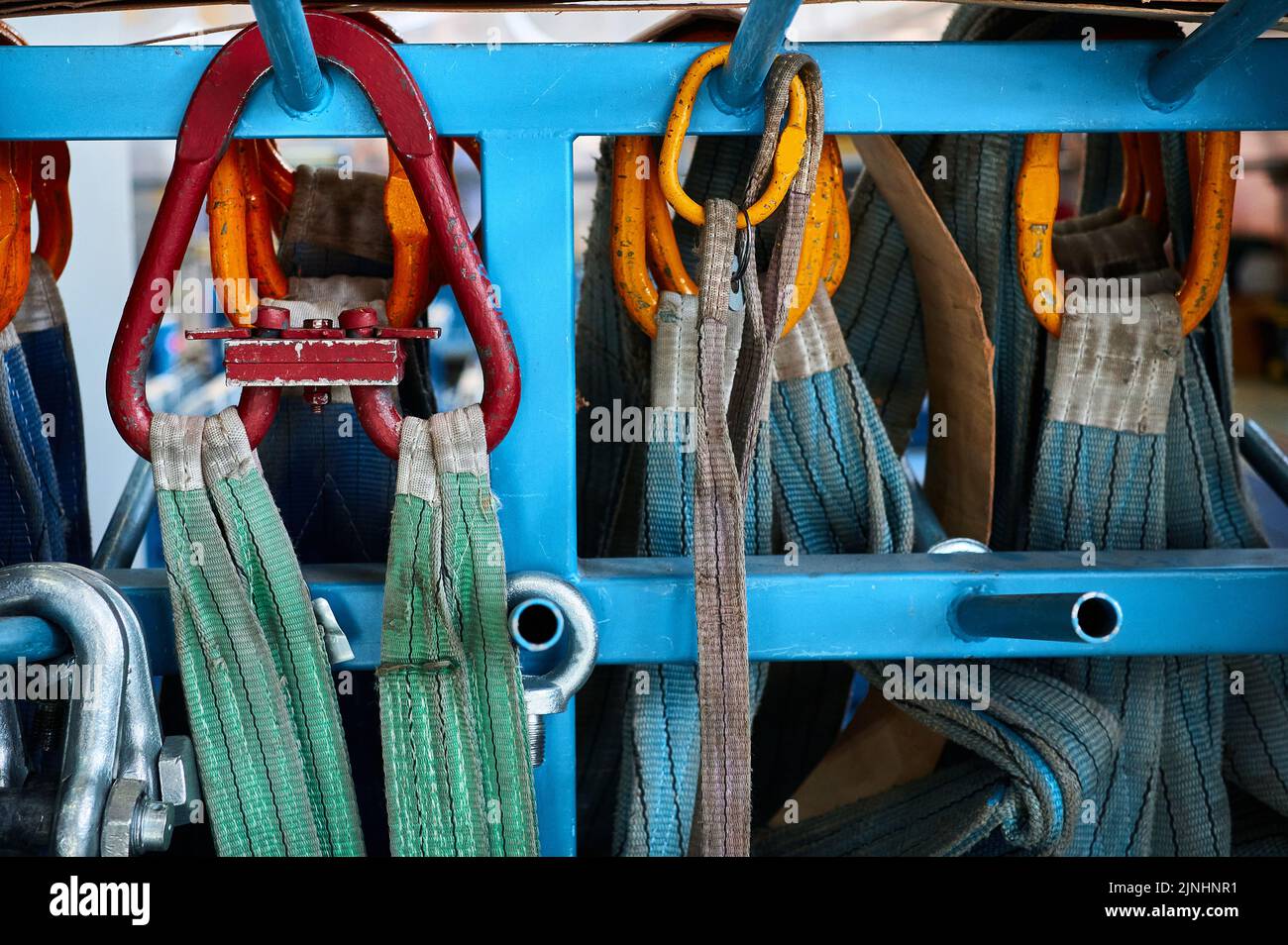 Rigging equipment with strops hangs on rack in warehouse Stock Photo