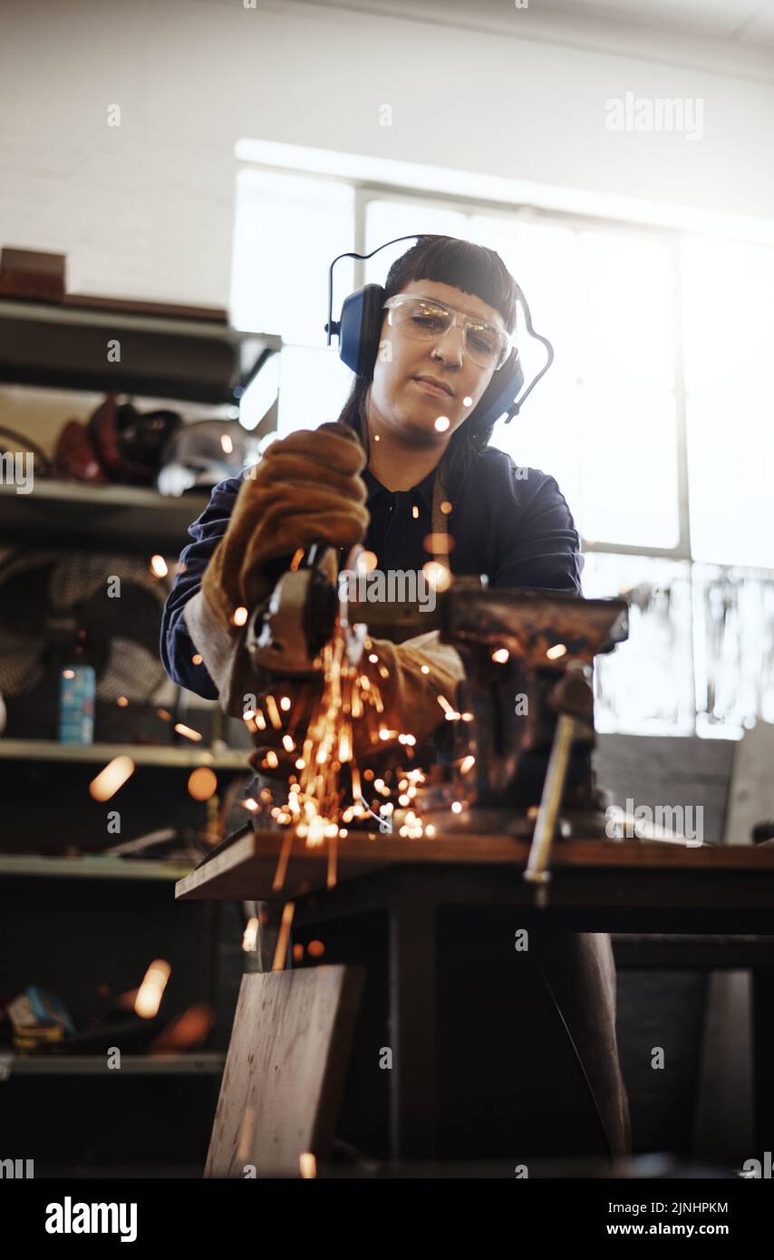 Taking the edge off. an attractive young female artisan using an angle