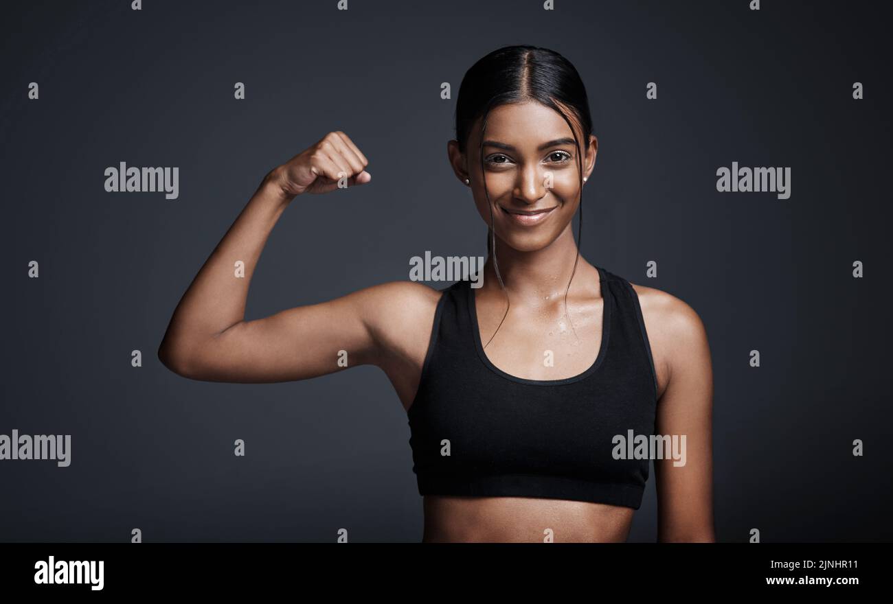 Young Beautiful Sporty Woman Flexing Biceps Closeup on Gray Background  Stock Photo - Alamy