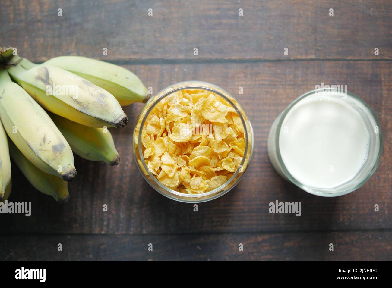 Top view of corn flakes , banana and milk on table  Stock Photo