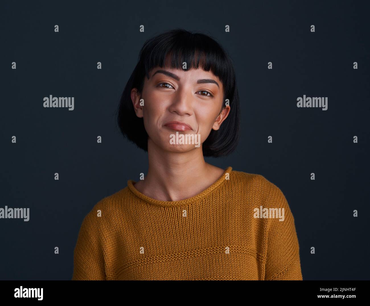 Aww, pretty please. Studio shot of an attractive young woman pouting against a dark background. Stock Photo