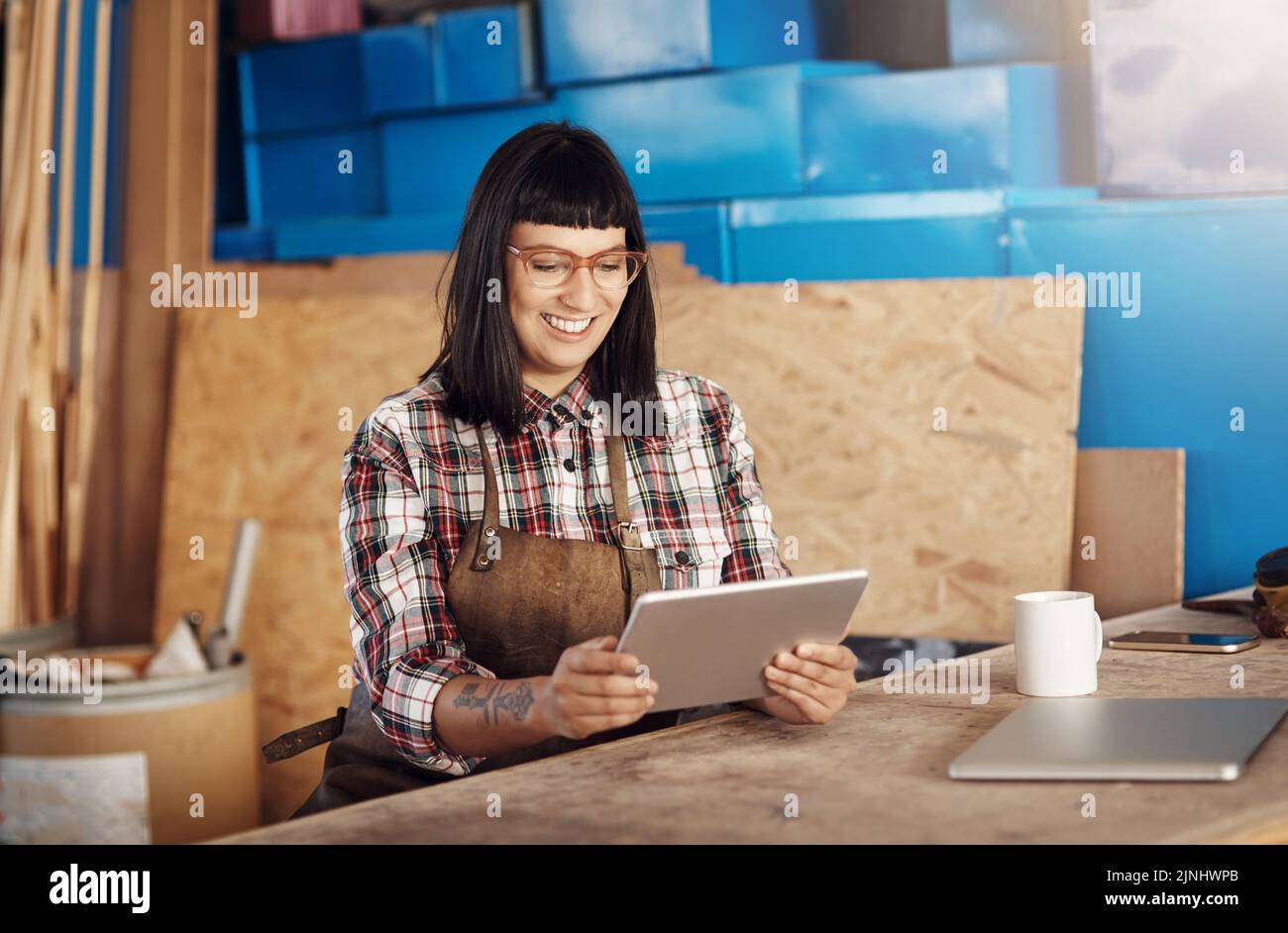 Shes in her element. an attractive young woman working on her tablet while sitting in her creative workshop. Stock Photo