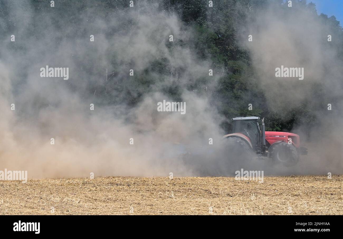 Sieversdorf, Germany. 10th Aug, 2022. A farmer drives a tractor and a ...