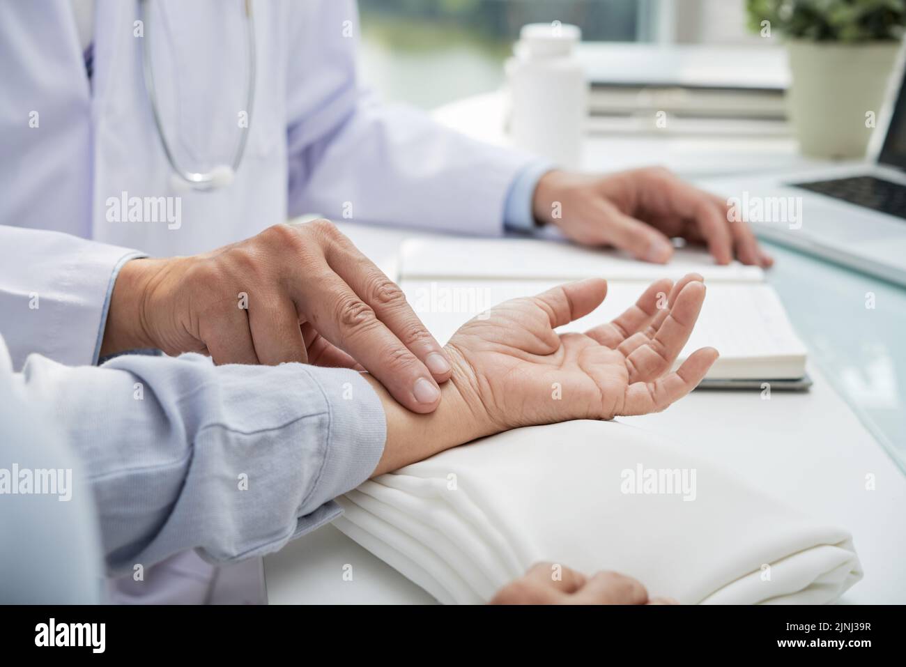 Closeup shot of unrecognizable cardiologist wearing white coat sitting