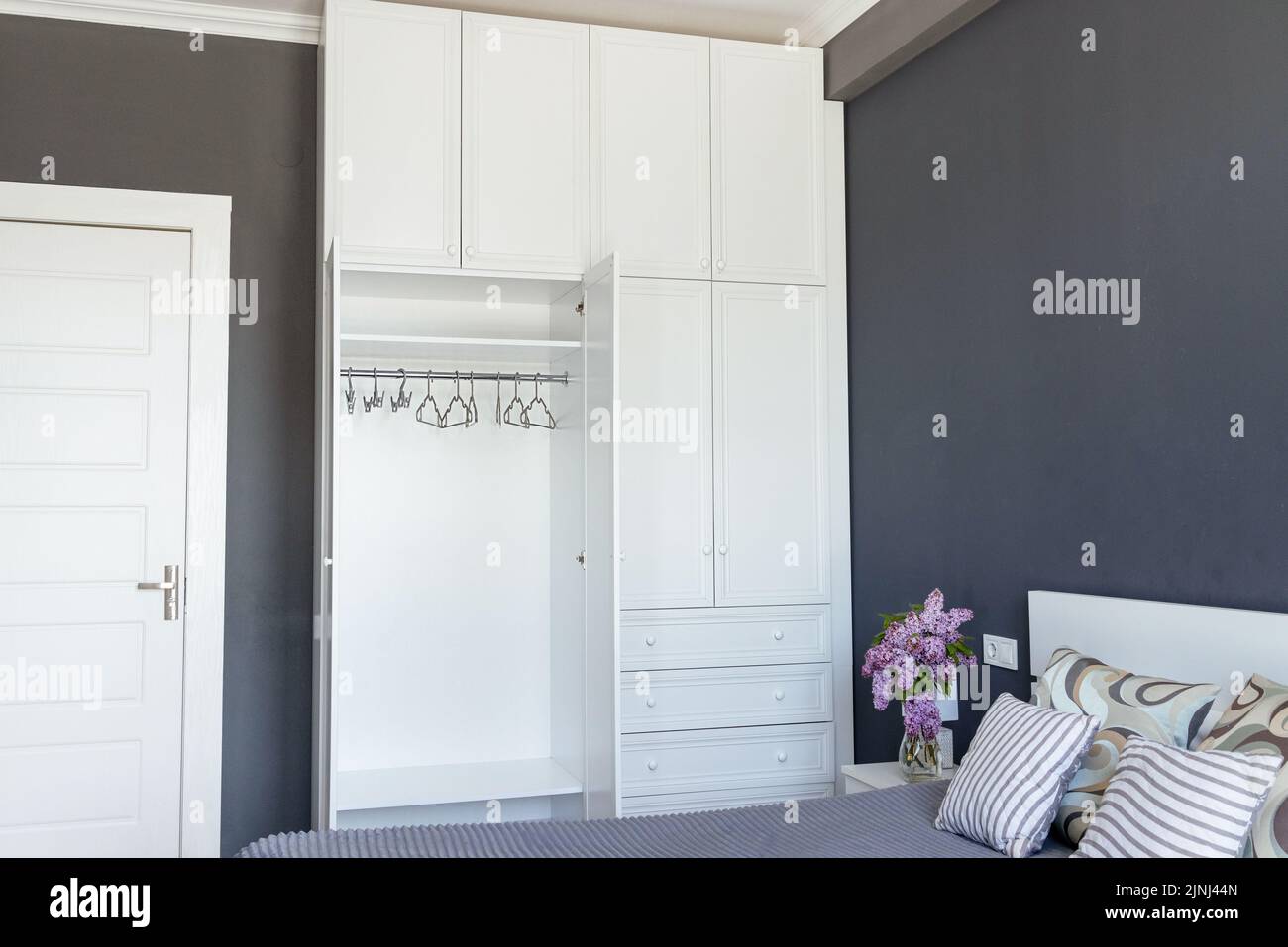 Close-up, empty white wardrobe with open doors in a gray room, copy paste Stock Photo