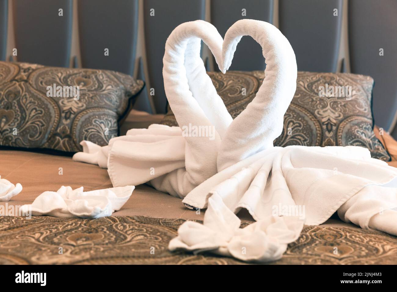 Swans made of white towels, romantic decoration of a honeymoon suite Stock Photo