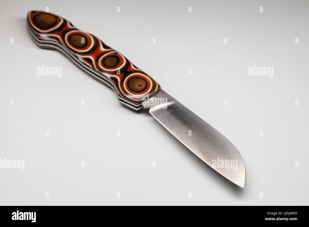 Turkish jackknife with sharp stainless steel blade and polymer handle with soft geometric pattern. Close up photo with selective soft focus Stock Photo
