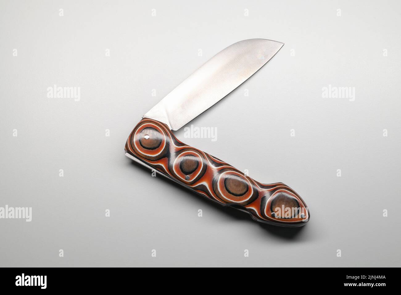 Half folded Jackknife with sharp steel blade and polymer handle with soft geometric pattern Stock Photo