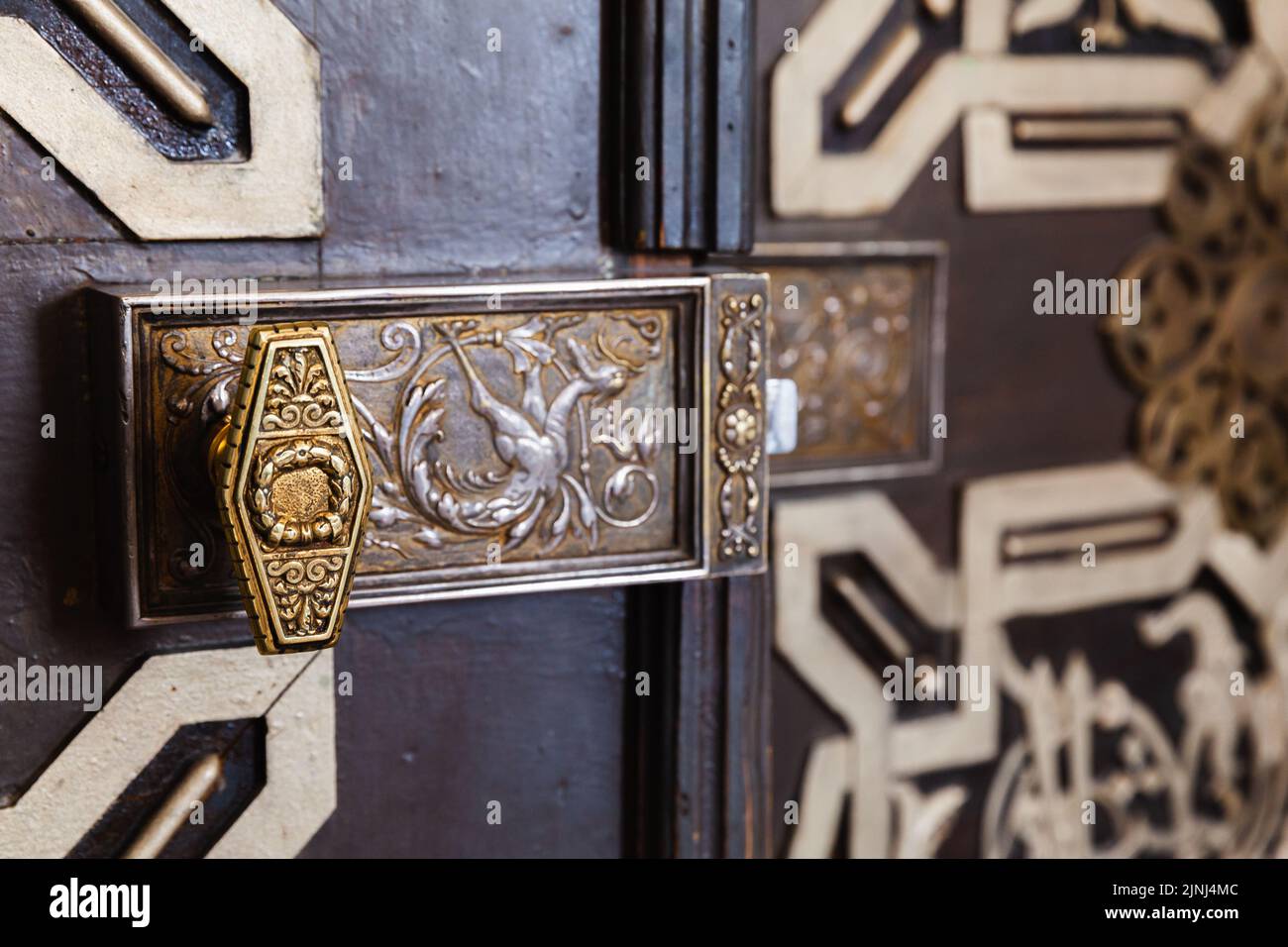 Vintage lock on an old oriental wooden door decorated with ornaments Stock Photo
