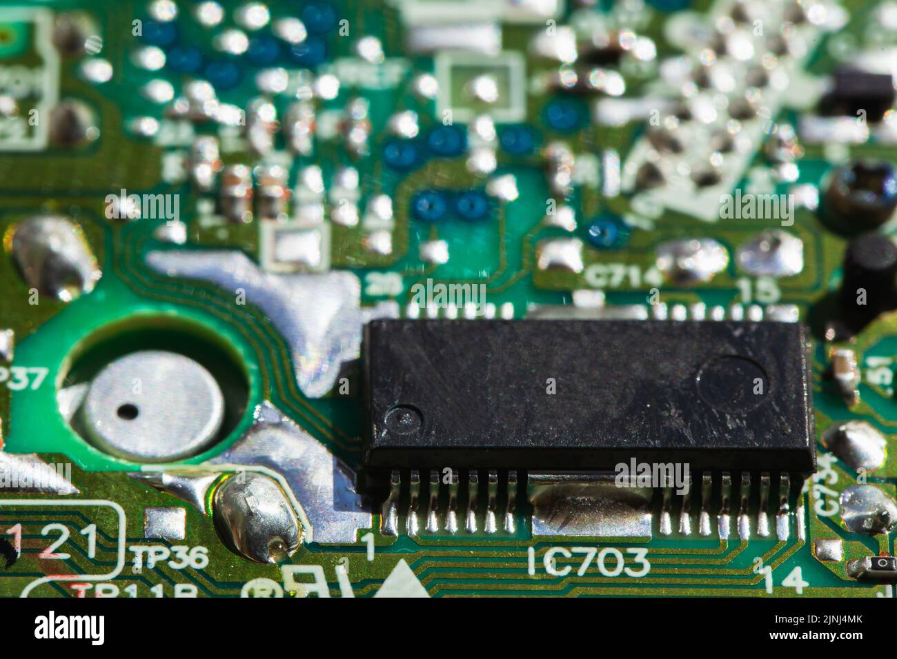 Chip and capacitors mounted on a green printed circuit board, close up photo with selective focus Stock Photo