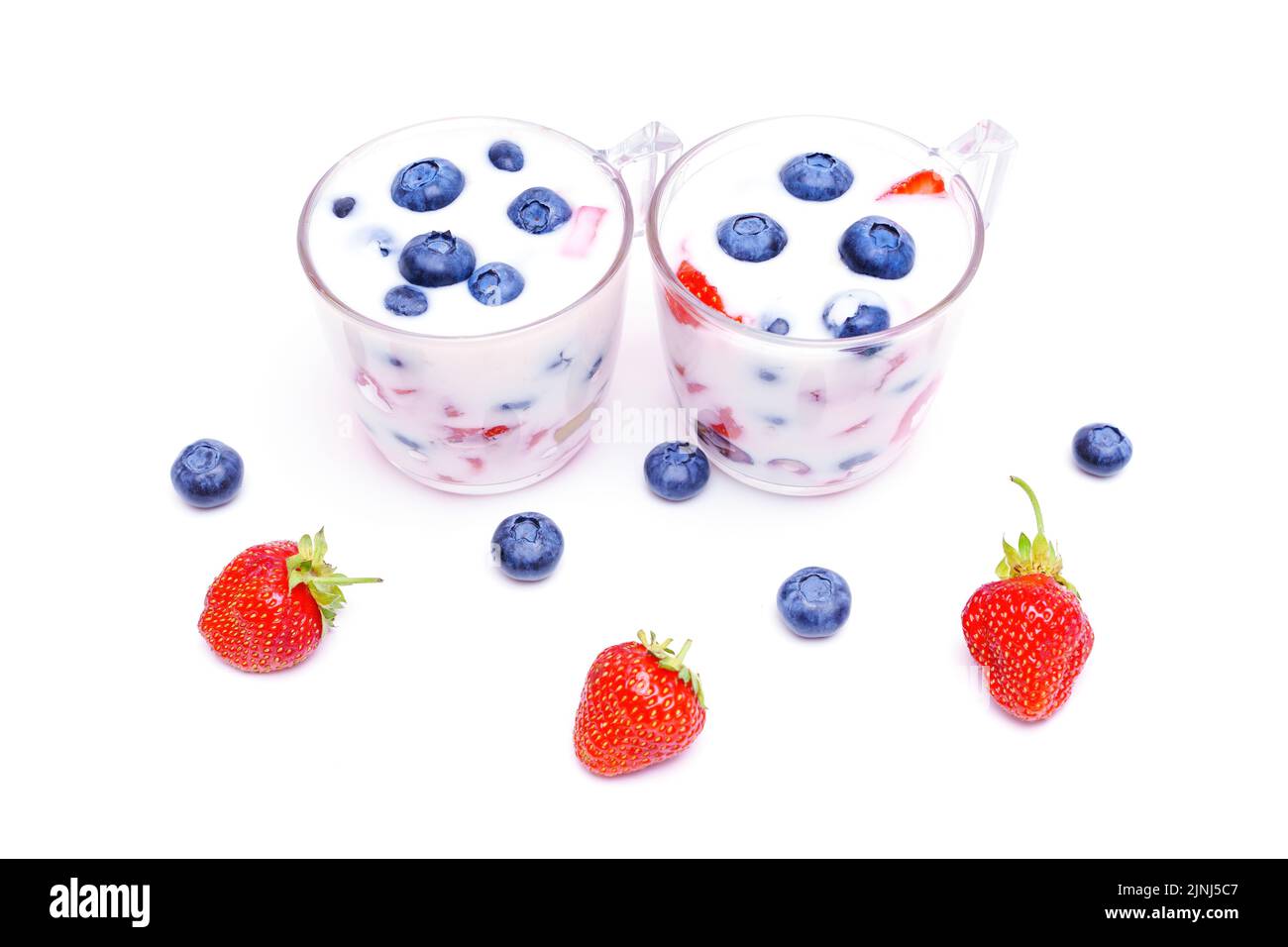 Homemade yogurt with fresh blueberries and strawberries on white. Stock Photo