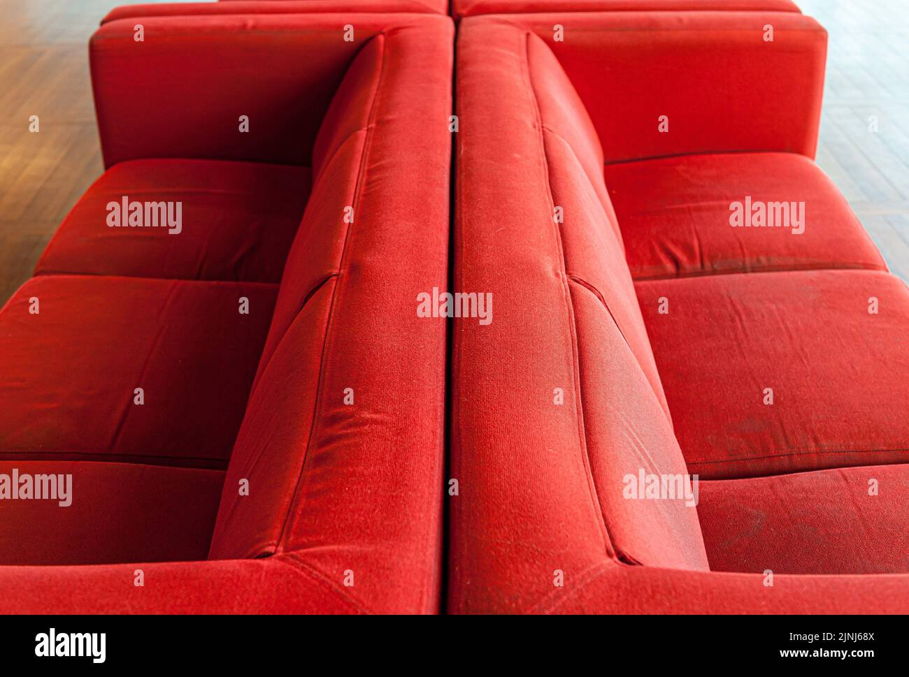 The two red sofas against each other in a room Stock Photo