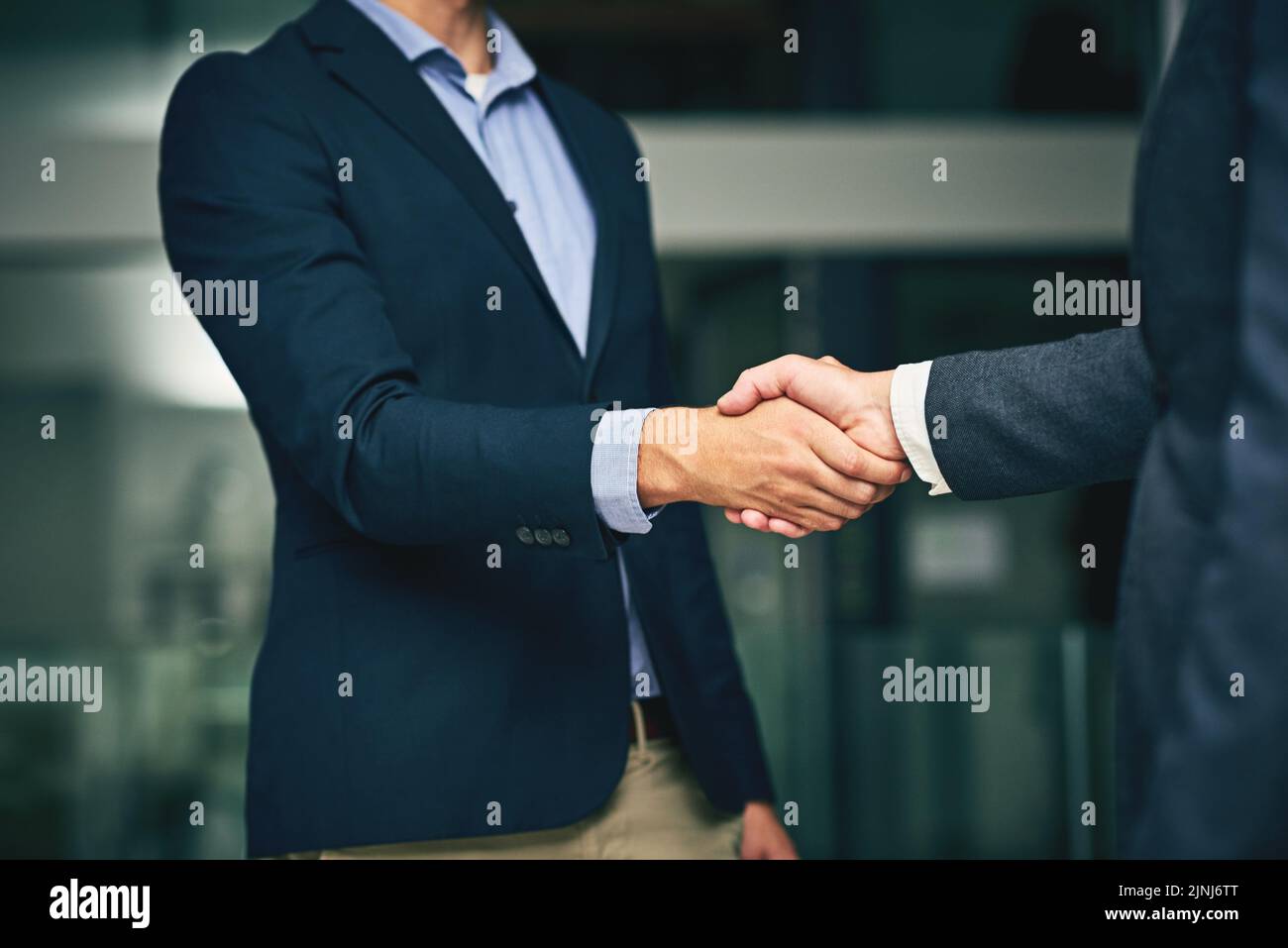 Closeup of businesswomen shaking hands during a meeting in an office. Colleagues finalizing a successful promotion, deal and merger. Coworkers greet Stock Photo