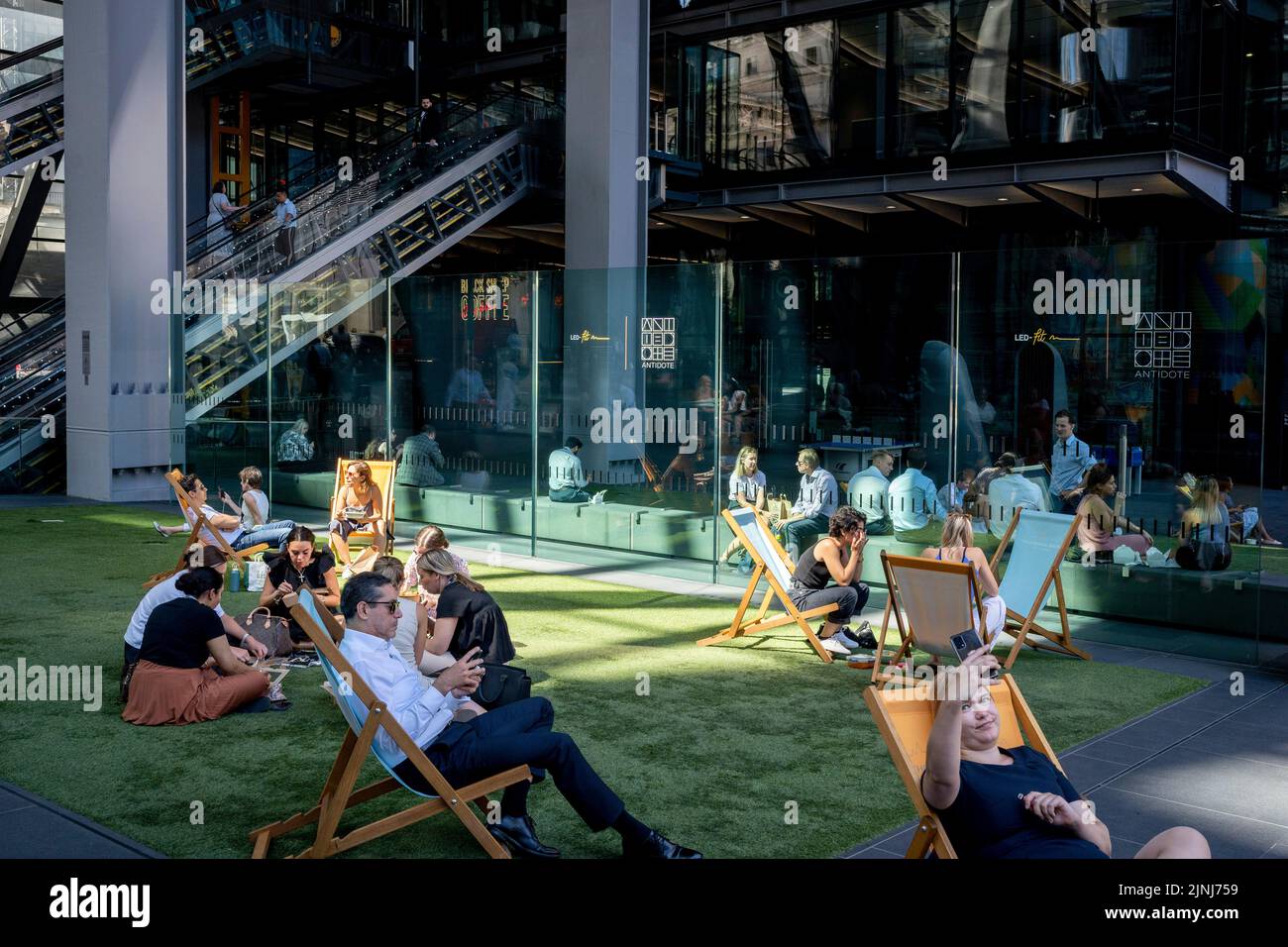 Office workers take their lunch hour beneath the architecture of the Leadenhall Building during the August heatwave in the City of London, the capital's financial district, on 11th August 2022, in London, England. Stock Photo