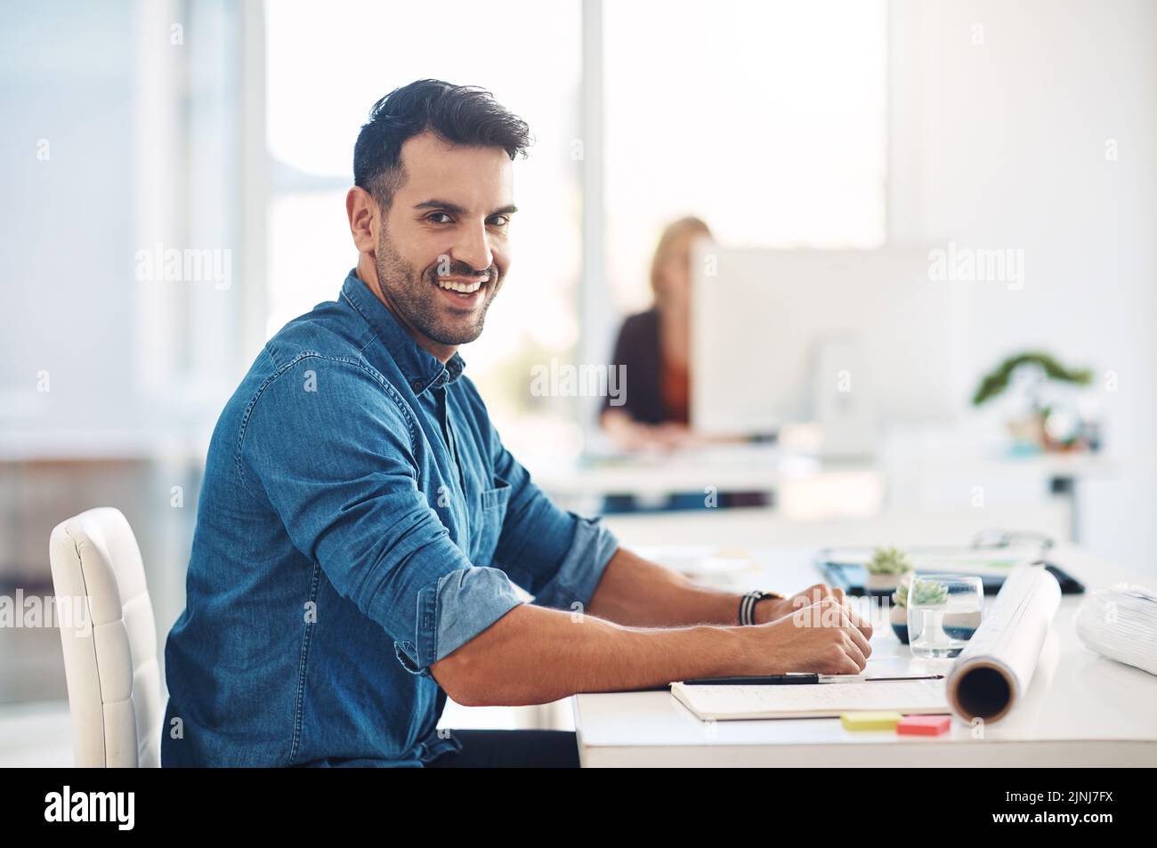 Happy creative businessman working at his desk, doing admin and taking notes while in an office at work. Portrait of a cheerful, smiling and Stock Photo