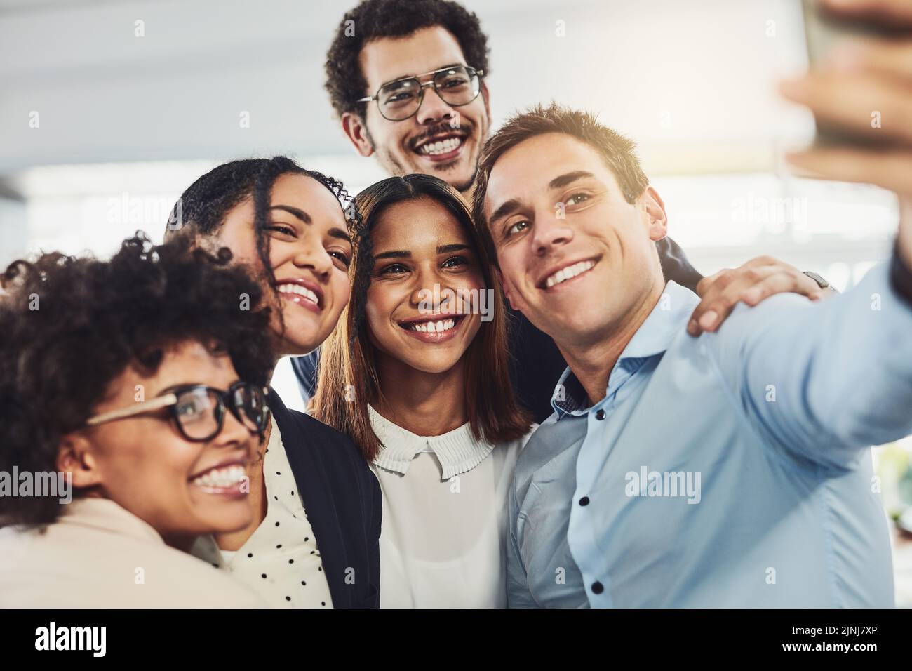 Happy, diverse and carefree colleagues taking a selfie to share on social media on their break. An excited young group of employees having fun at the Stock Photo