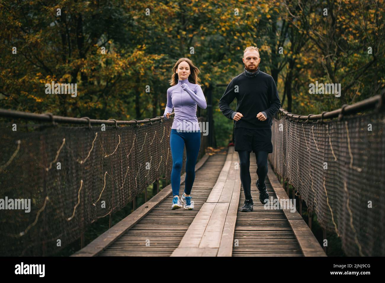 Early morning workout. Young athletic man and woman performing a