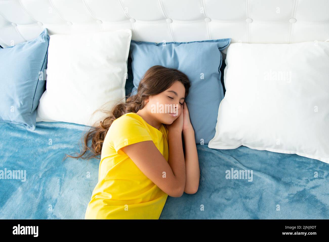 Teenager sleep in bed on pillows at home. Kid lying and sleeping on bed