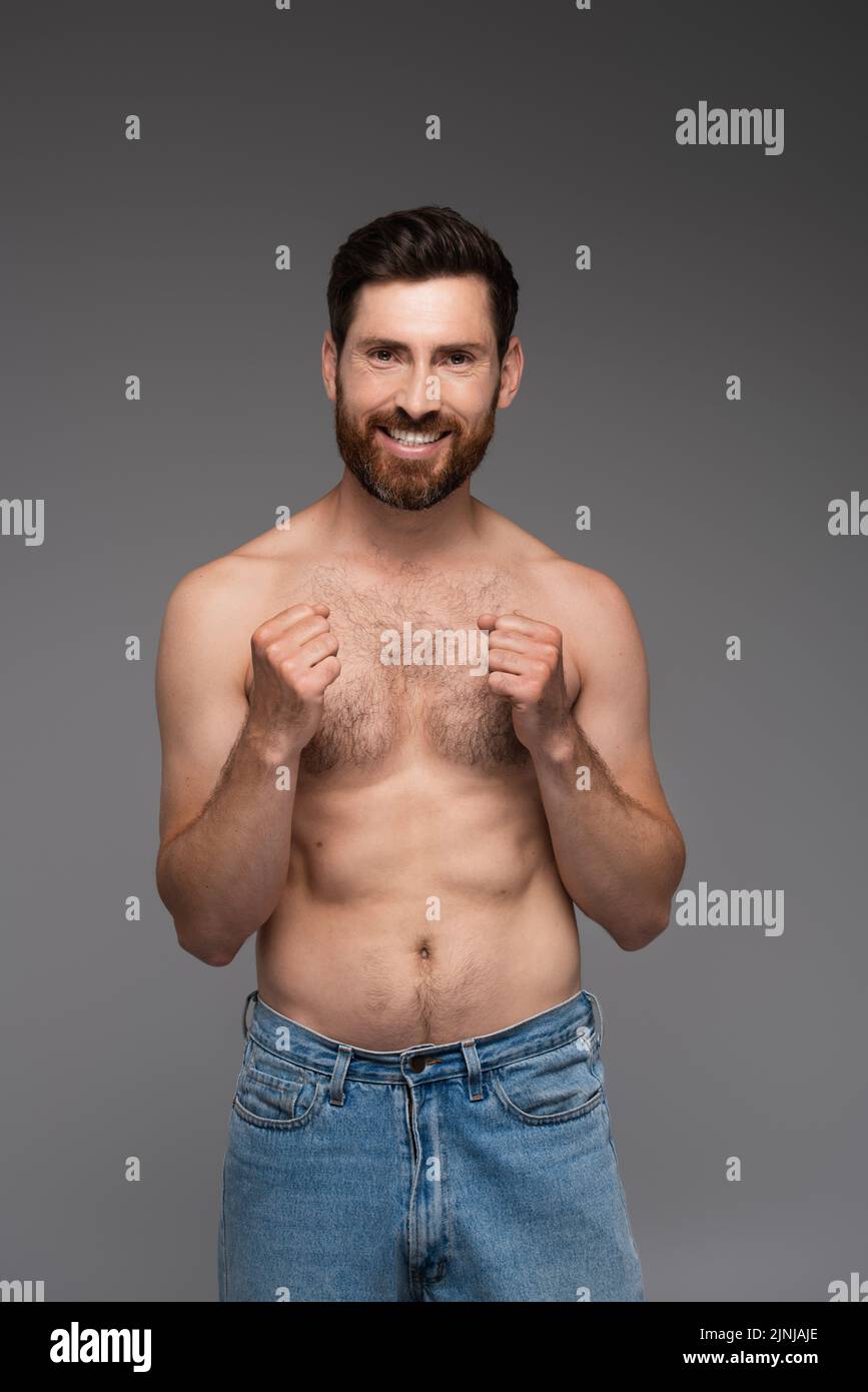 shirtless and cheerful man with hair on chest smiling isolated on grey,stock image Stock Photo