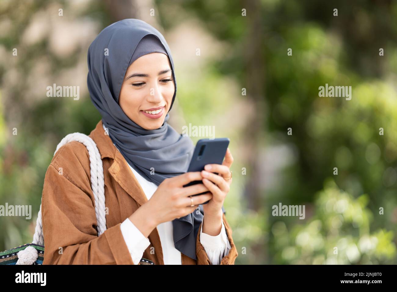 Smiling muslim woman using a mobile. Close up Stock Photo