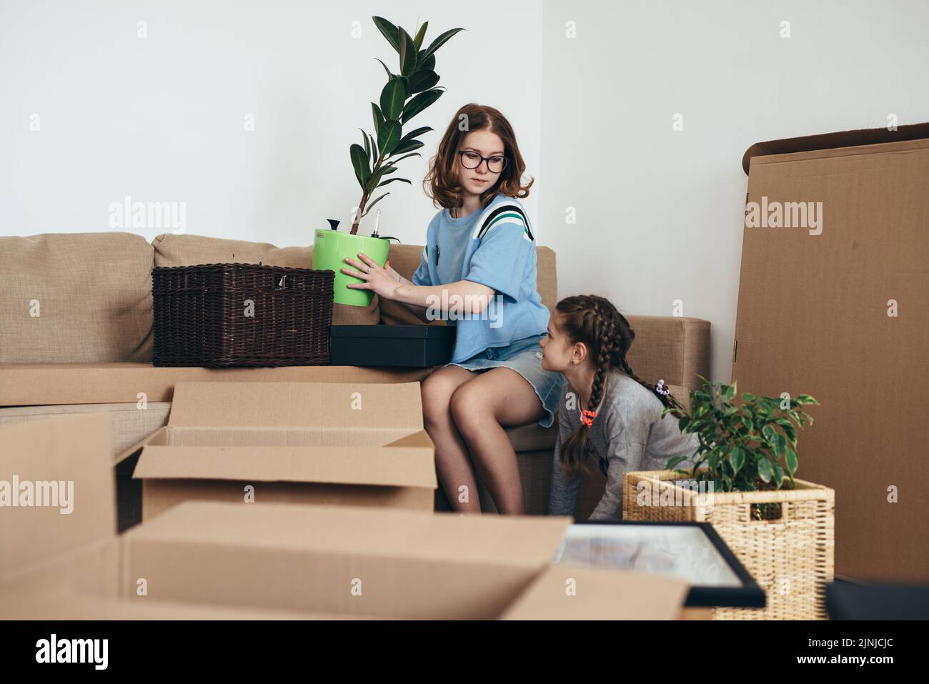 Family unpacking cardboard boxes at new home Stock Photo - Alamy