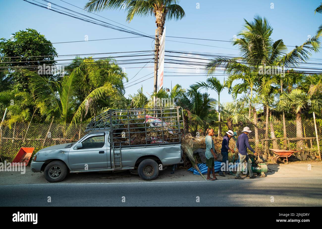 KOH SAMUI ISLAND, THAILAND. 25 March 2016; Local life on Samui Island. Image of old pickup truck and three men doing business. Stock Photo