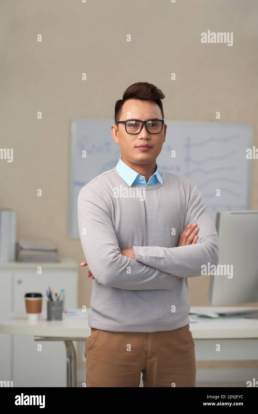 Confident young businessman in glasses looking at camera Stock Photo