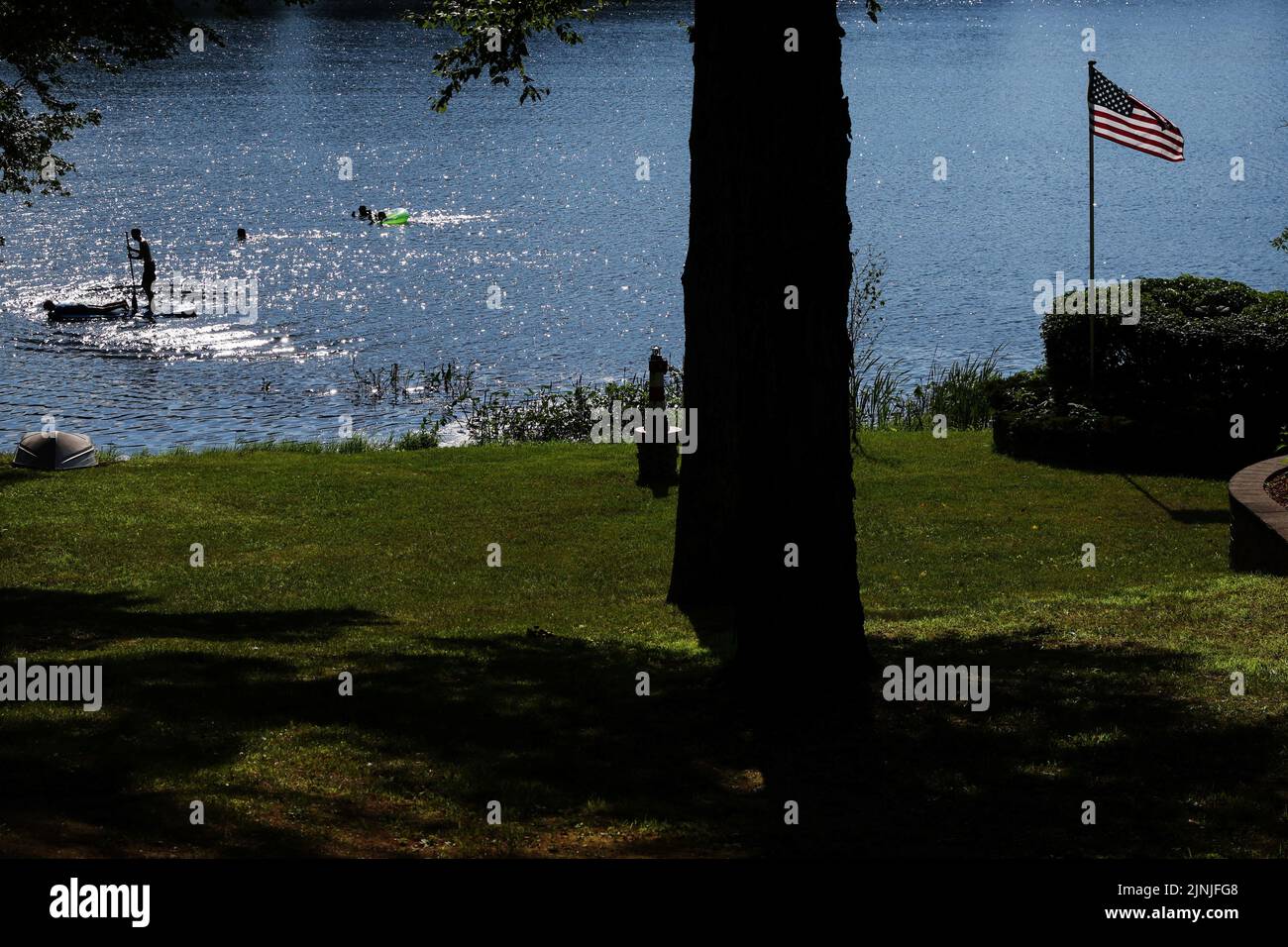 Kids swim and paddle in Schroon Lake in the Adirondack Park, during hotter than normal temperatures, in Schroon, New York, U.S., July 20, 2022. REUTERS/Shannon Stapleton Stock Photo