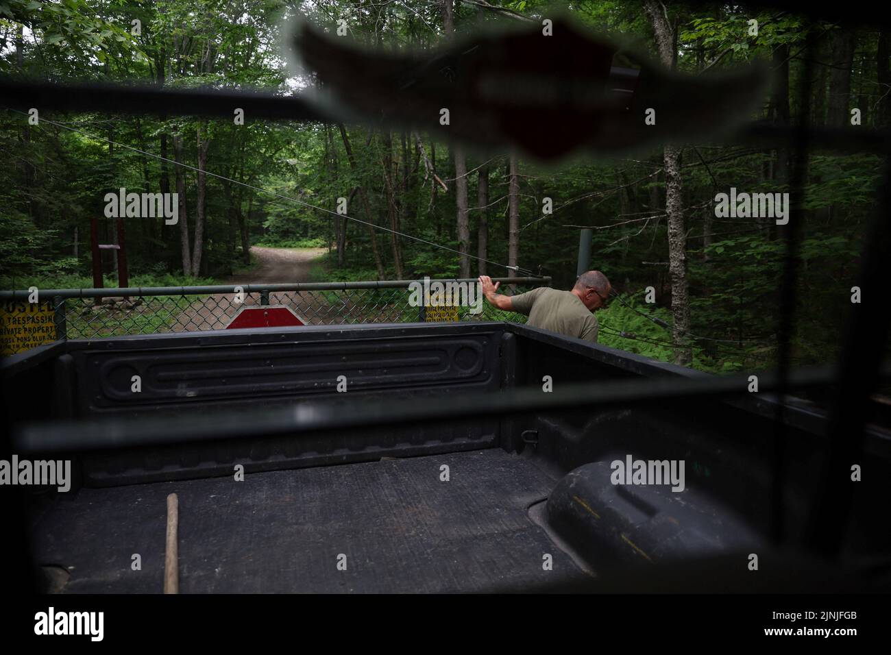 Rick Bennett closes the gate off of New York State Route 28N to the Moose Pond Club near Minerva, New York, U.S., July 20, 2022. REUTERS/Shannon Stapleton Stock Photo