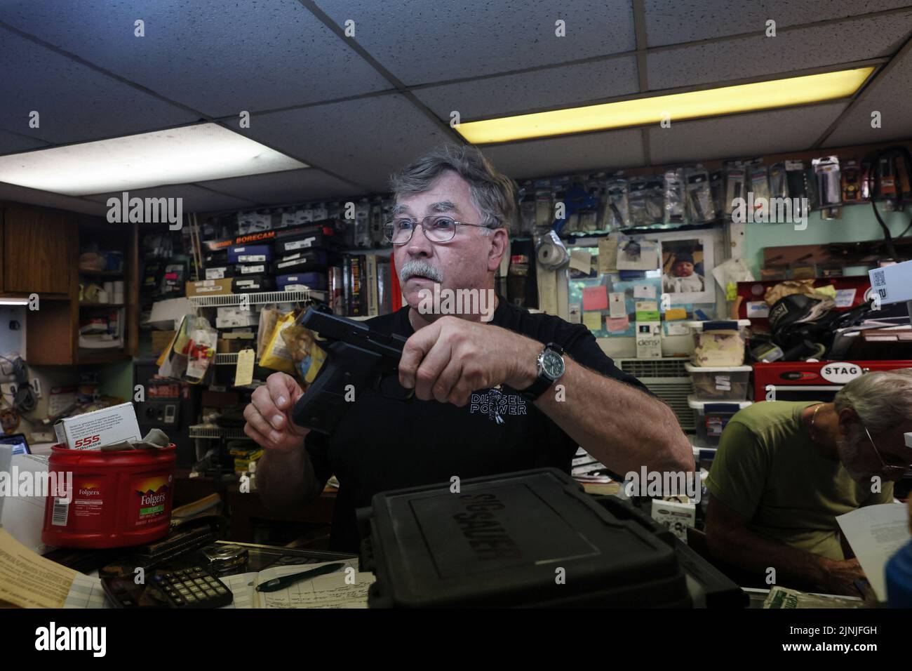 Rich Selmeyer, co-owner of The Gun Shop at MacGregor's, holds a firearm being traded in at the shop in Lake Luzerne, New York, U.S., July 19, 2022. REUTERS/Shannon Stapleton Stock Photo