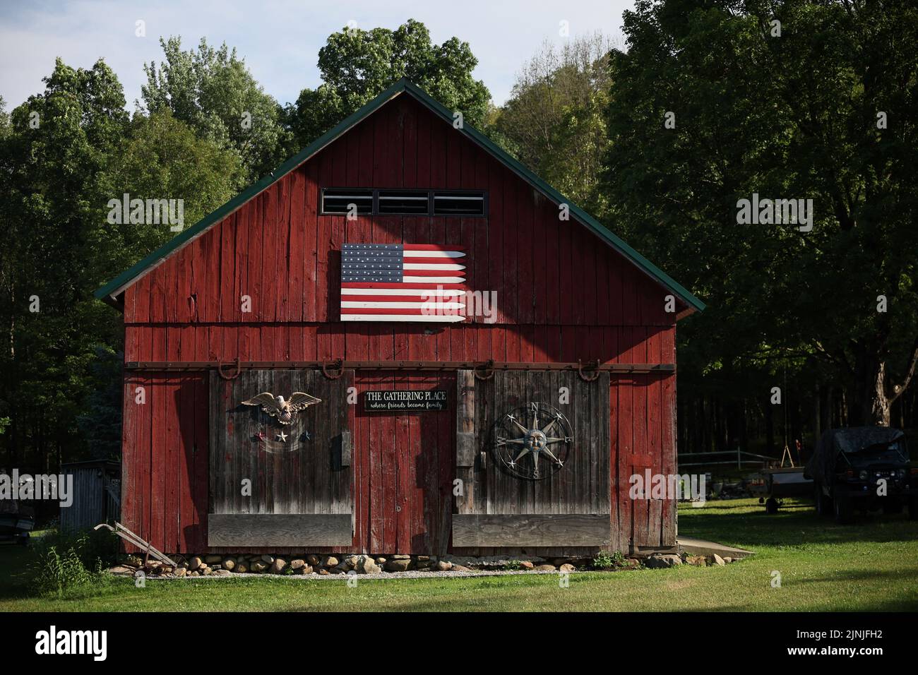 A barn stands with a U.S. flag along a roadside in Lake Luzerne, New York, U.S., July 19, 2022. REUTERS/Shannon Stapleton Stock Photo