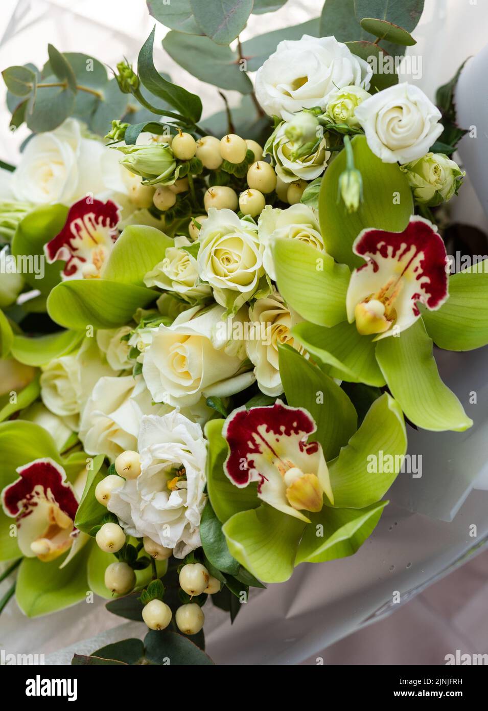 Fresh flowers for any holiday. Close up of a bouquet in green color scheme with roses, eustoma and irises. Concept of floristics and flower arrangemen Stock Photo