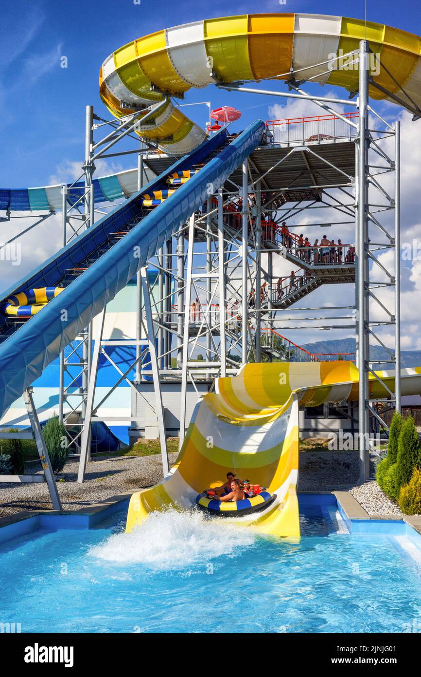 Liptovsky Mikulas, Slovakia - August 4, 2022: People are sliding down on colorful water slides in aquapark Stock Photo