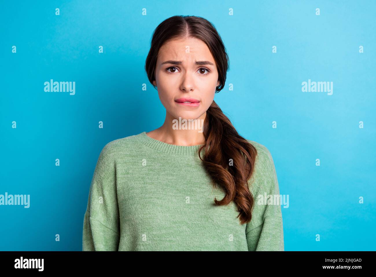 Photo Of Unsatisfied Nice Girl Biting Lips Anxious Worry Look Camera Isolated On Blue Color 