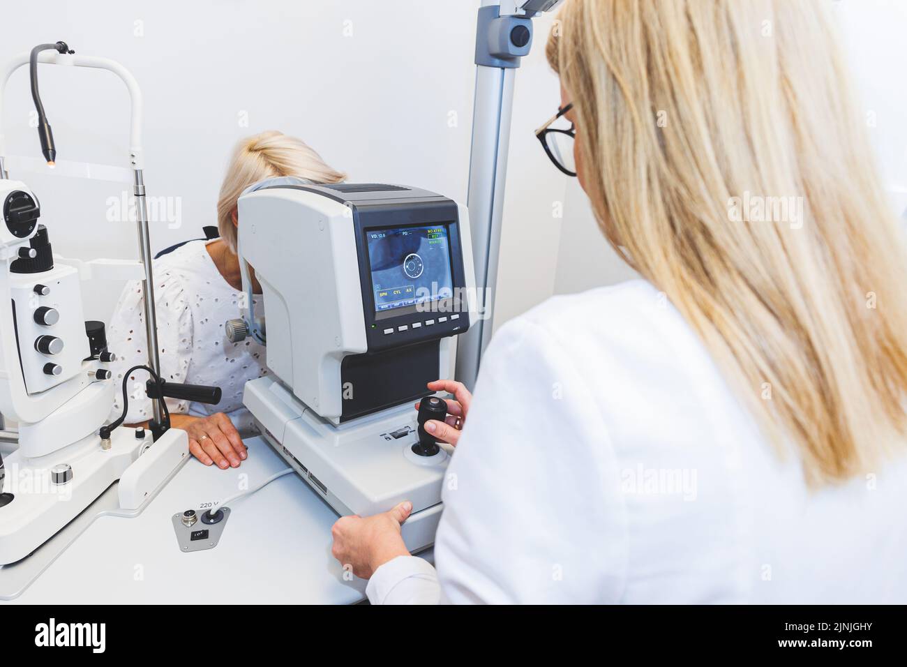 Eye doctor checking vision with modern equipment. Eye examination Stock Photo