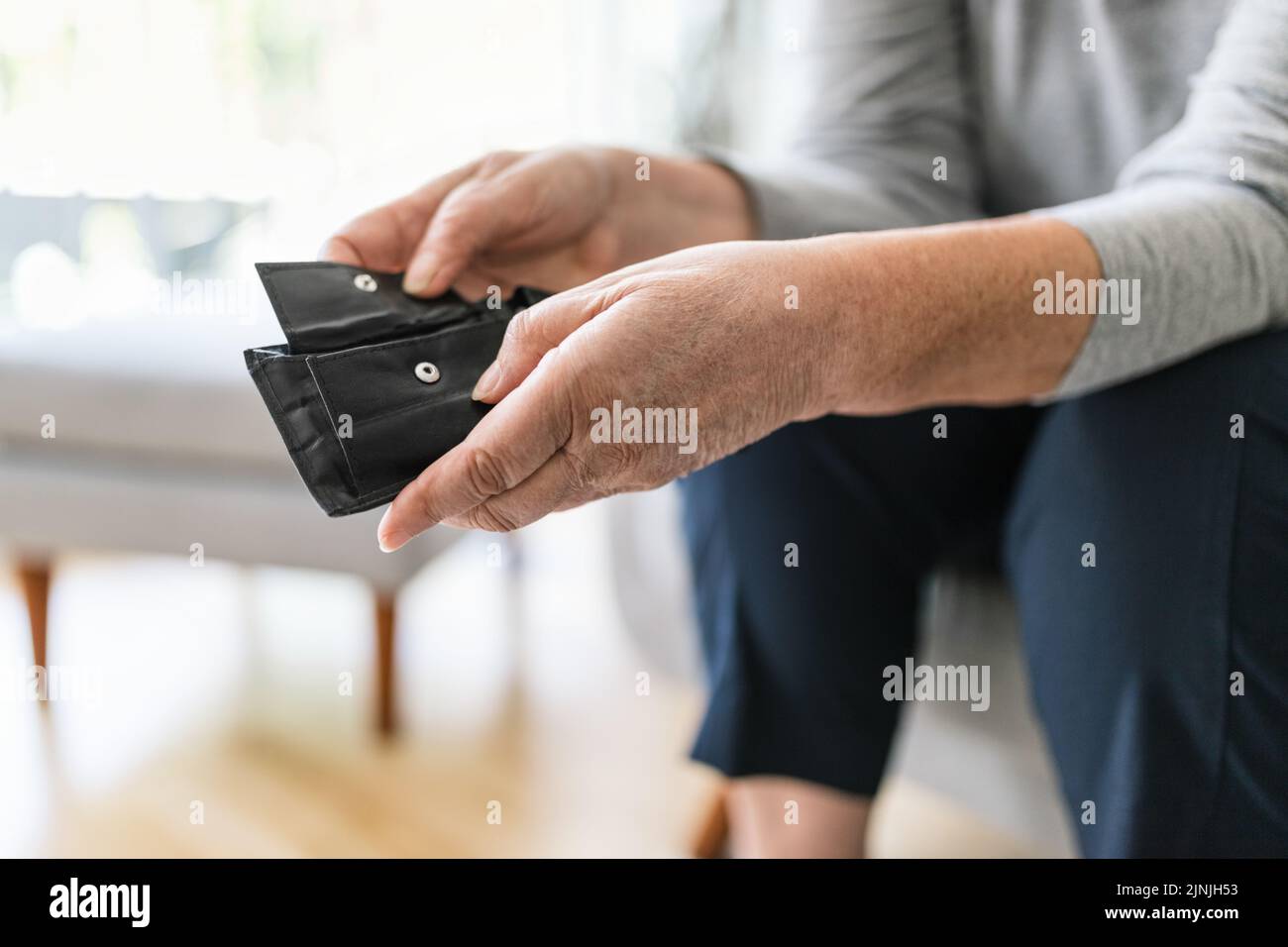 Desperate elderly woman unhappy with the rising cost of living Stock Photo