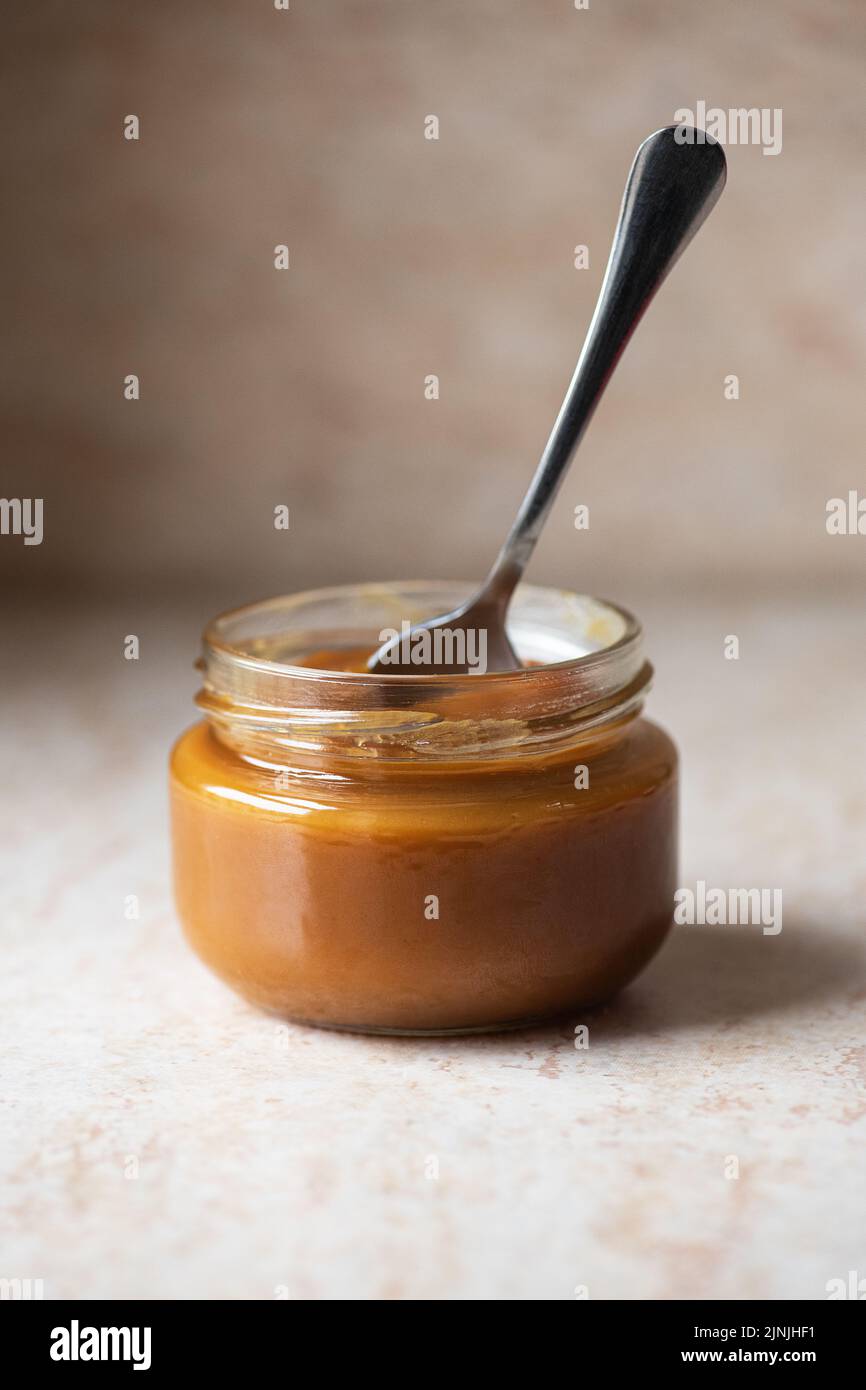 Homemade creamy caramel in a jar. Close up. Stock Photo