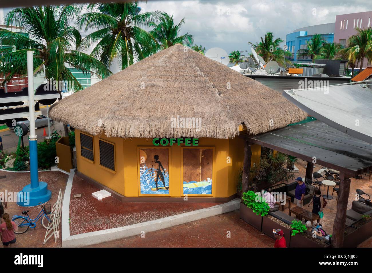 A yellow coffee shop with a thatched roof near the cruise port in