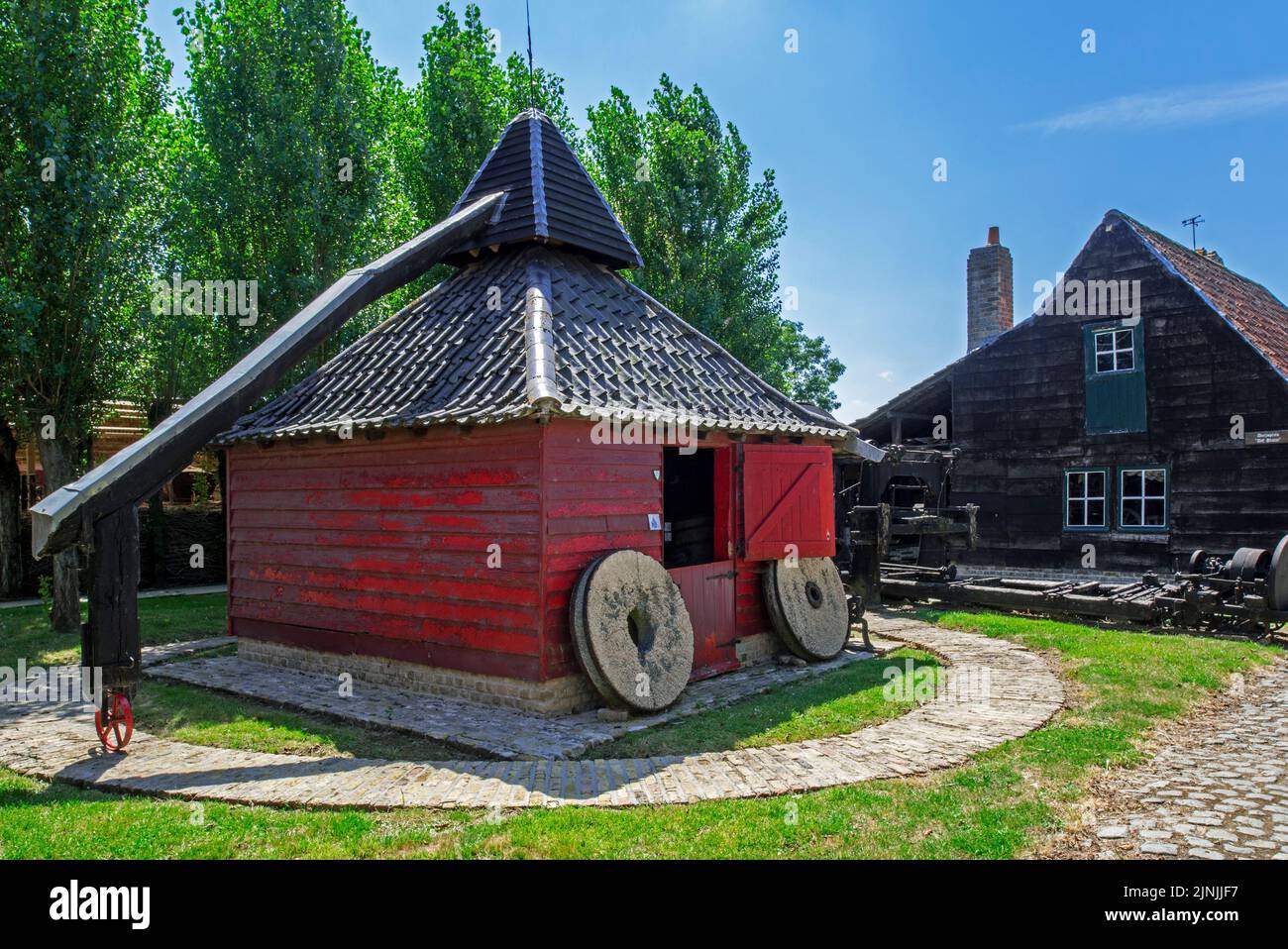 Old Flemish wooden horse mill which uses animal power for grinding grain at the open air museum Bachten de Kupe, Izenberge, West Flanders, Belgium Stock Photo