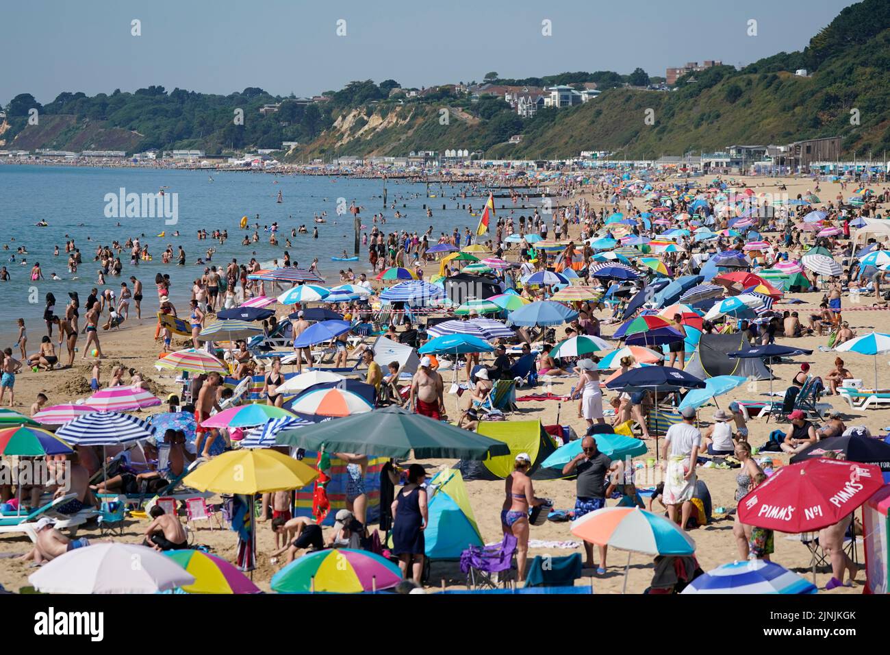 People gather in the hot weather at Bournemouth beach, Dorset. A drought is set to be declared for some parts of England on Friday, with temperatures to hit 35C making the country hotter than parts of the Caribbean. Picture date: Friday August 12, 2022. Stock Photo
